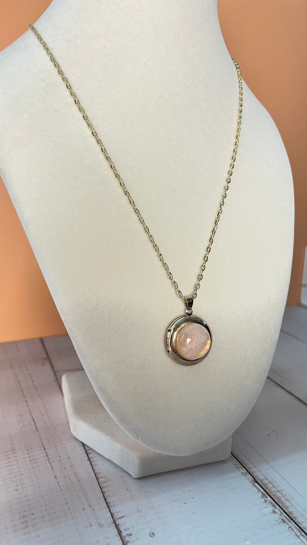 Necklace with a round pendant on a white mannequin bust.