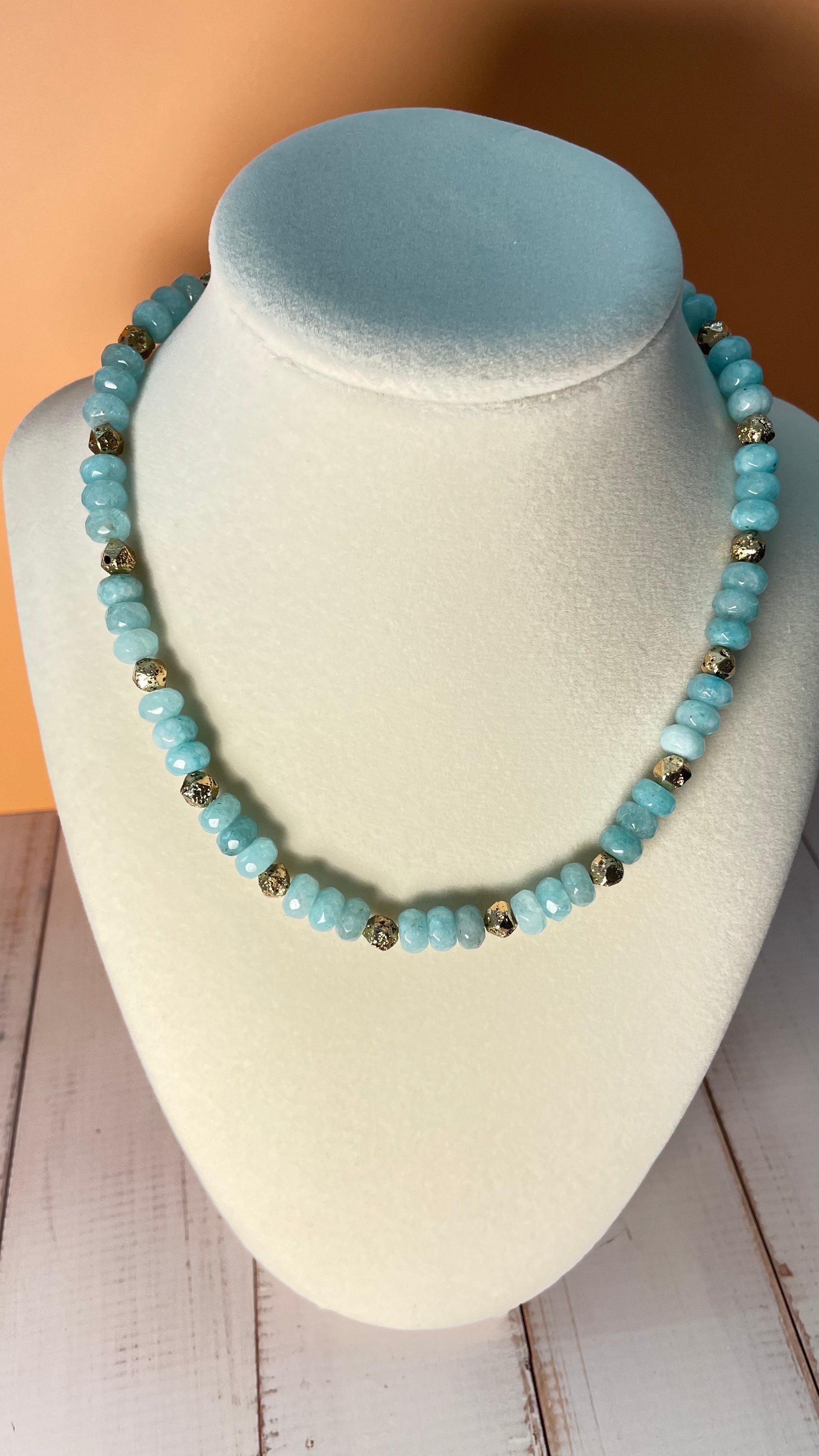 Turquoise dyed quartz and gold-plated lava accent bead necklace displayed on a mannequin bust