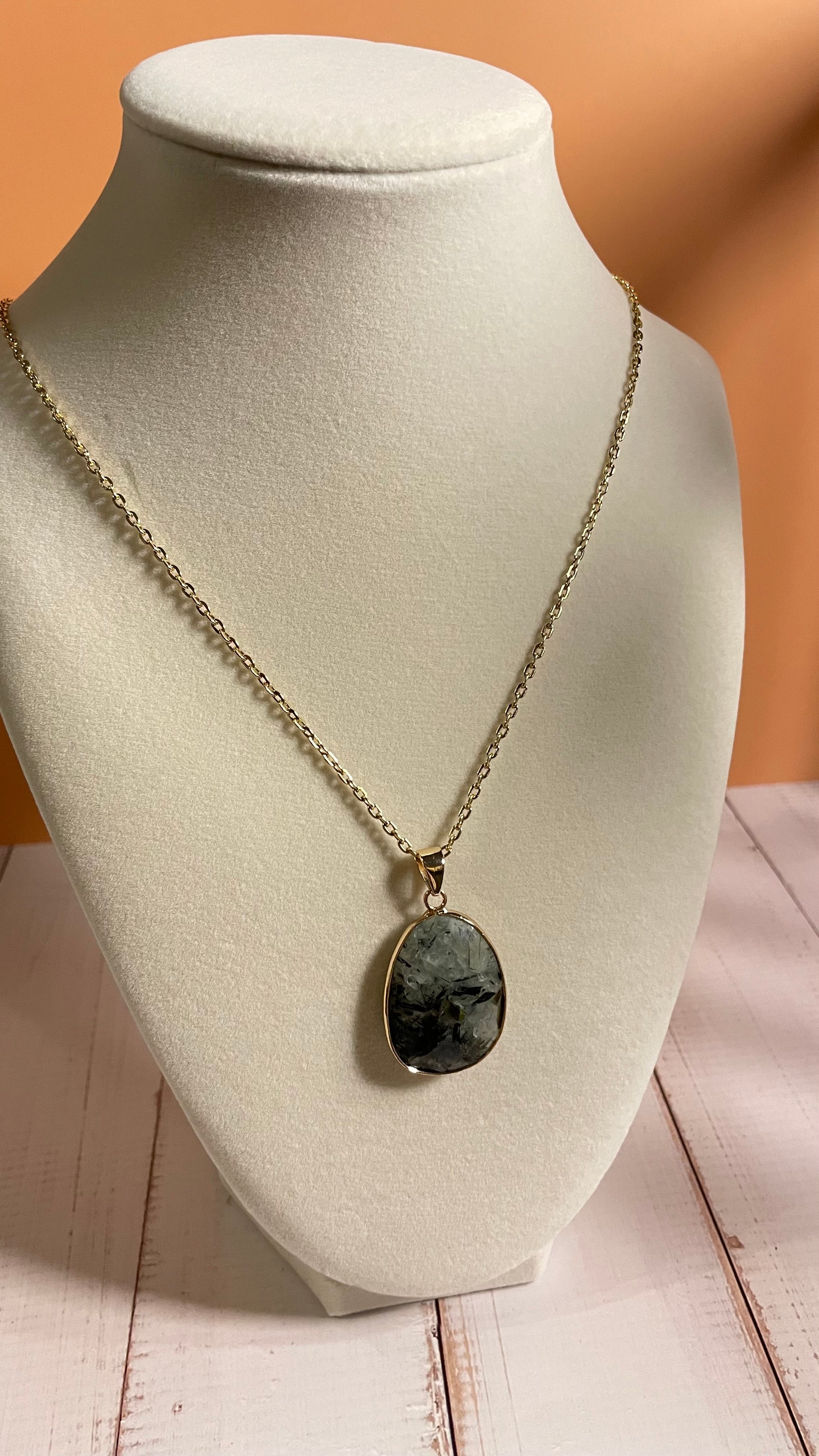 Prehnite Crystal Pendant Gold Chain Necklace on Cream Colored Display Bust